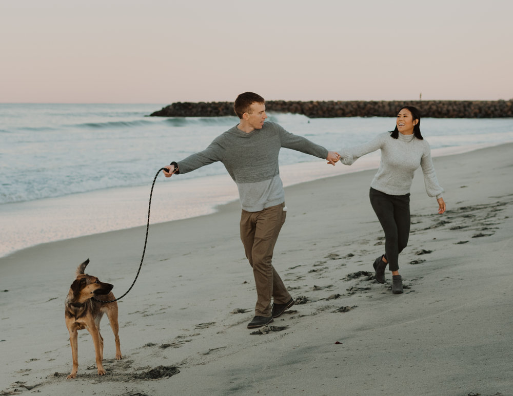 A husband and wife and their dog at Tamarack Beach in Carlsbad California