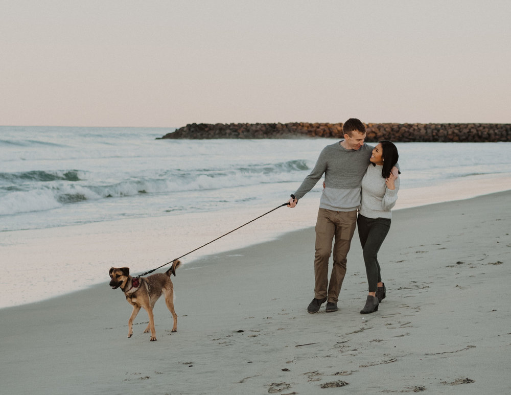 A husband and wife and their dog at Tamarack Beach in Carlsbad California
