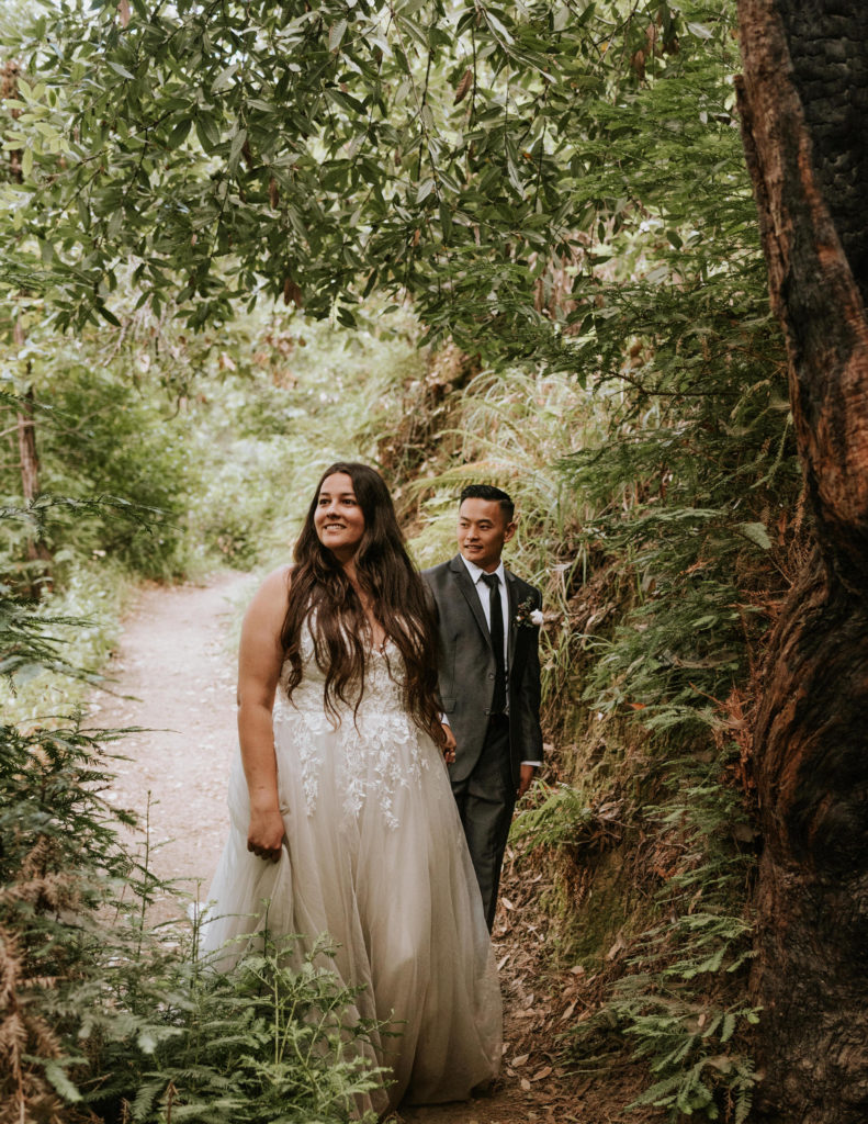 A bride and groom walking in the redwoods during their elopement in Big Sur.