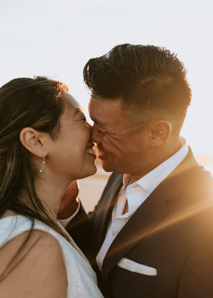 A bride and groom kissing during their elopement at Mission Beach in San Diego.