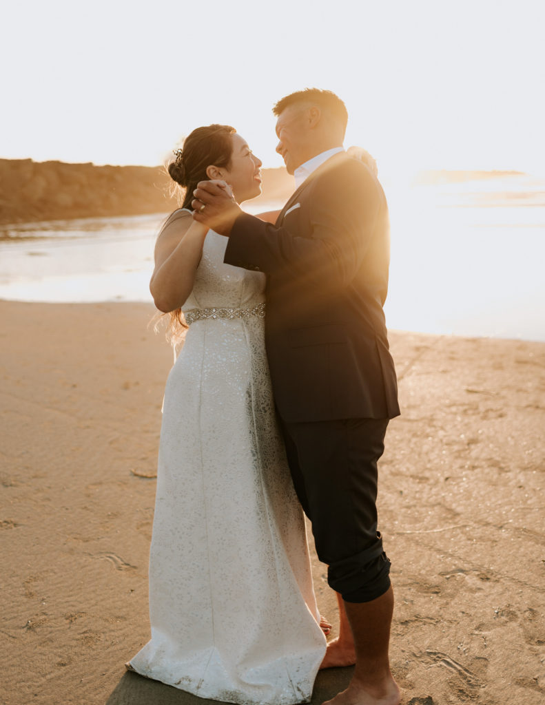 A bride and groom dancing during their elopement at Mission Beach in San Diego.