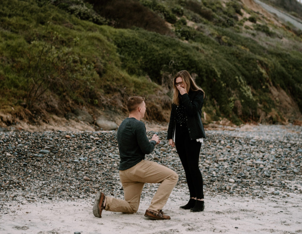A man surprising his girlfriend with a proposal on the beach in Encinitas, California