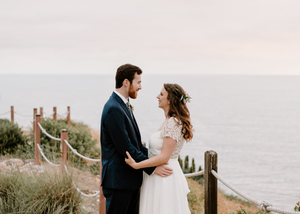 A bride and groom embracing at their wedding at Martin Johnson House in La Jolla, California.