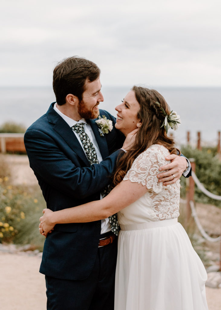 A bride and groom embracing at their wedding at Martin Johnson House in La Jolla, California.