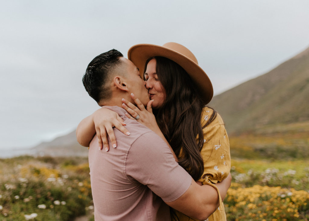A husband and wife kissing in a field in Big Sur during their elopement