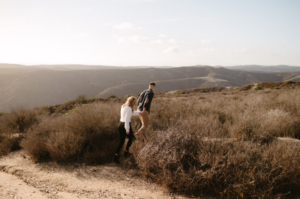 A couple walking the trails during their Top of the World engagement session in Laguna Beach.