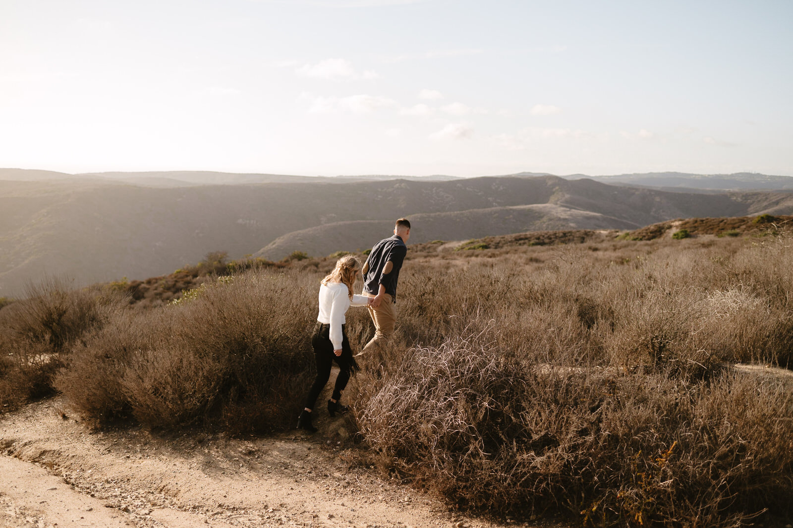 A couple walking the trails during their Top of the World engagement session in Laguna Beach.