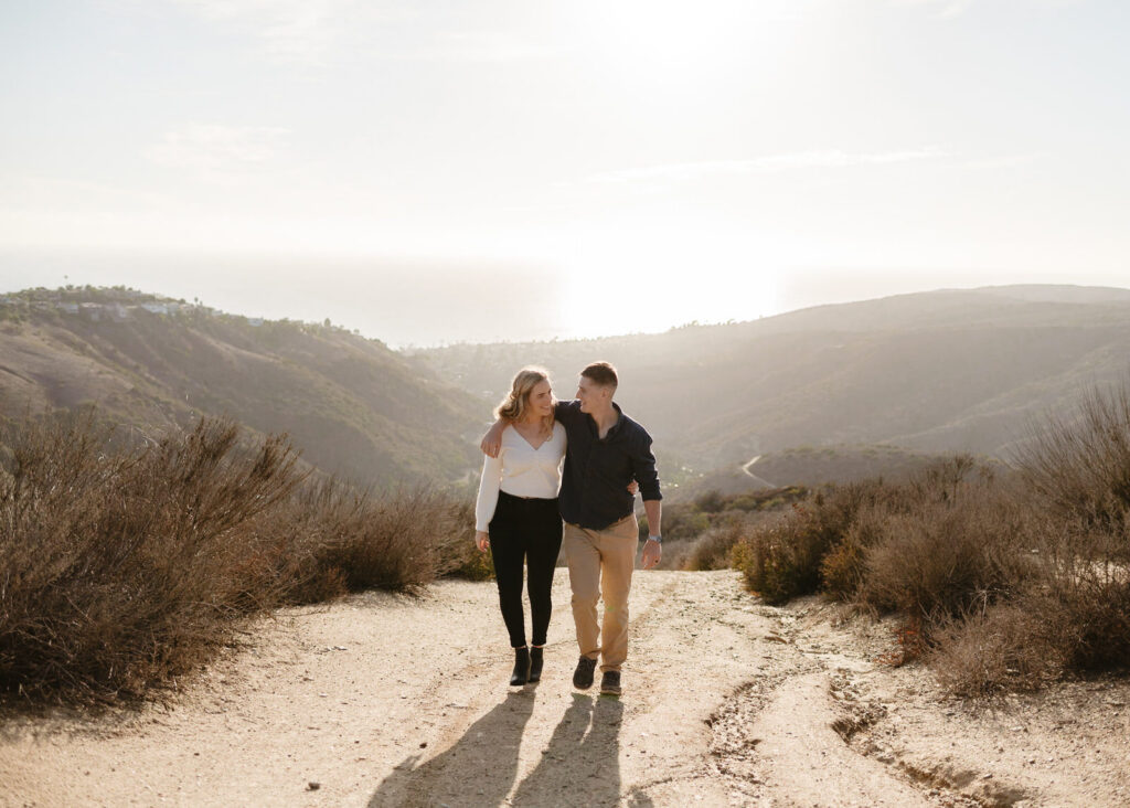 A couple walking the trails during their Top of the World engagement session in Laguna Beach.